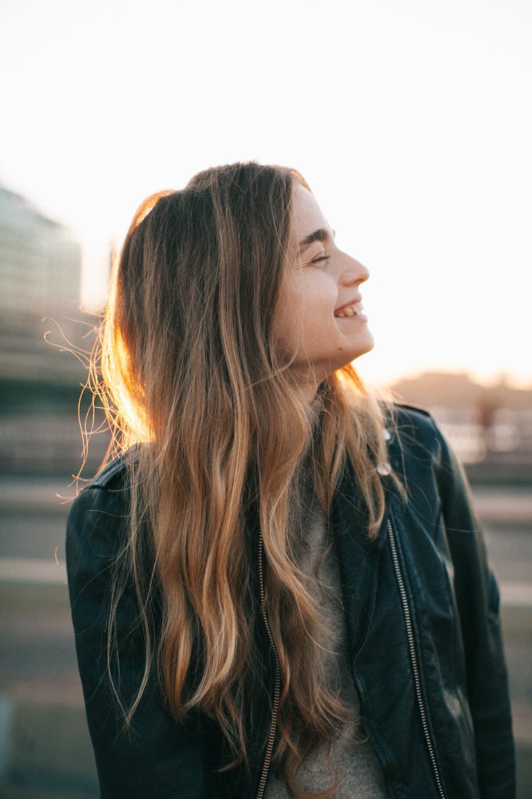 Smiling Woman Wearing Black Leather Jacket Outdoors during Day