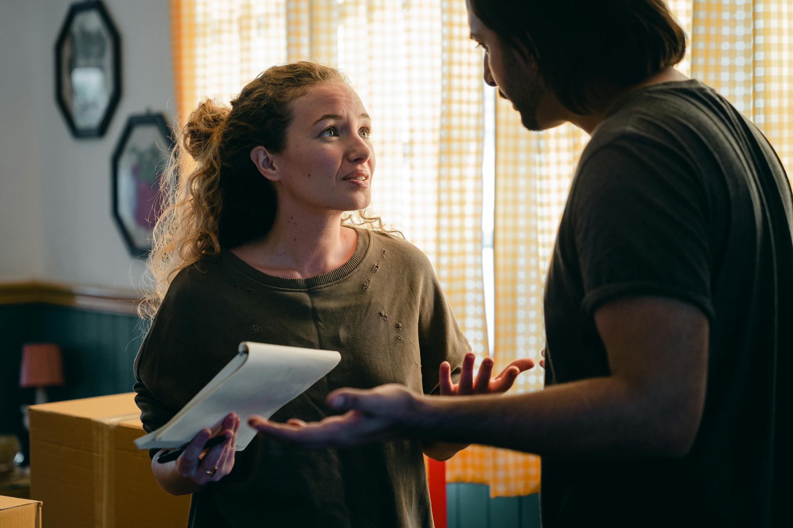 Worried couple with notebook looking at each other