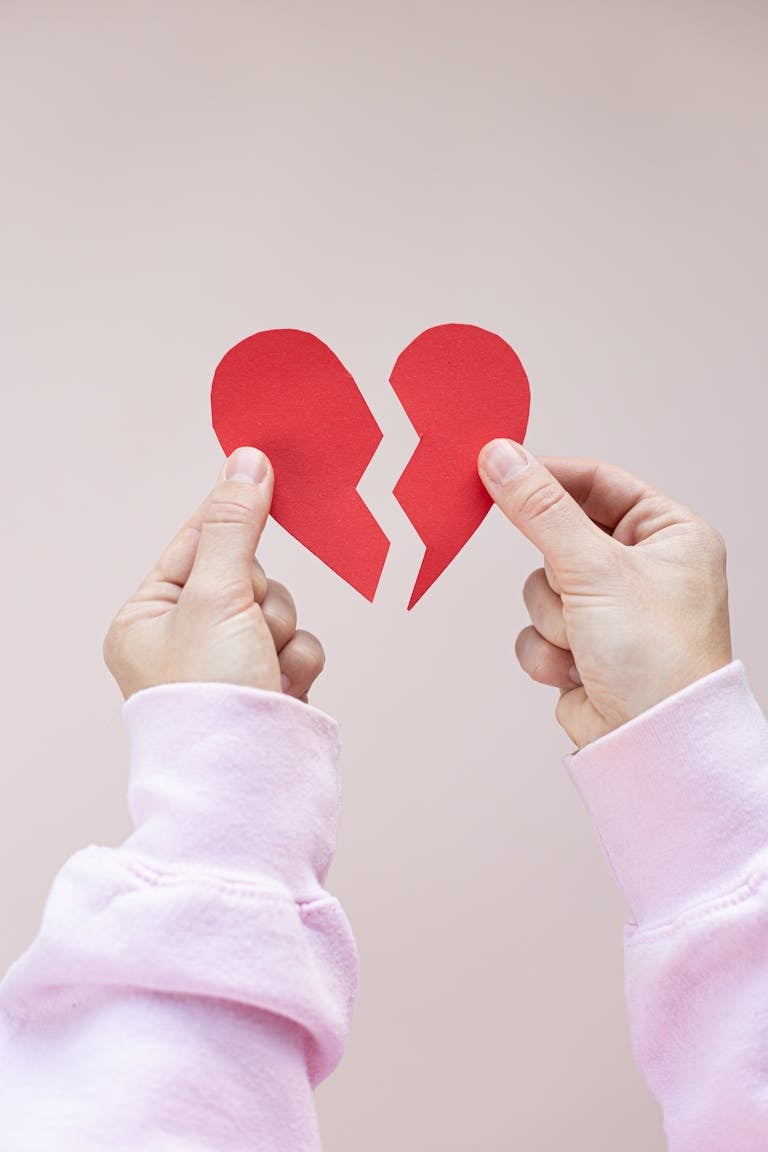 Crop person demonstrating red paper heart