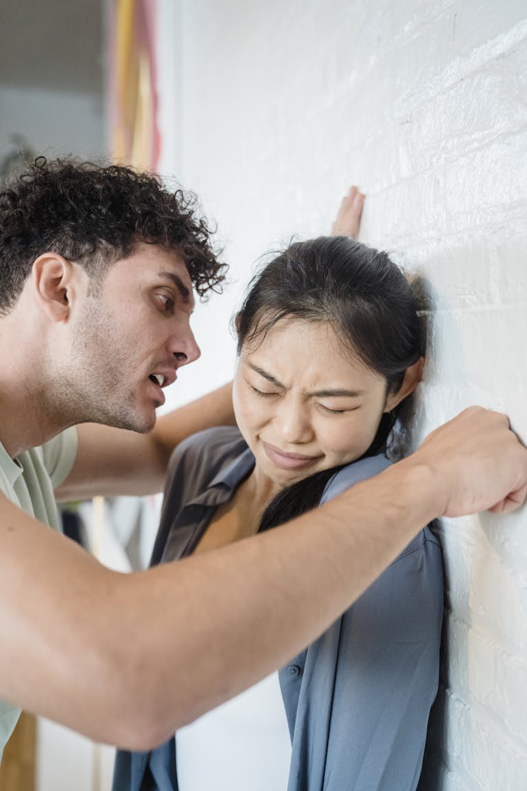 A man and woman in a heated argument indoors, depicting tension and conflict.