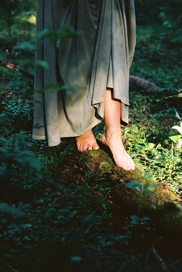 A serene moment capturing bare feet in a lush forest, dappled by sunlight.