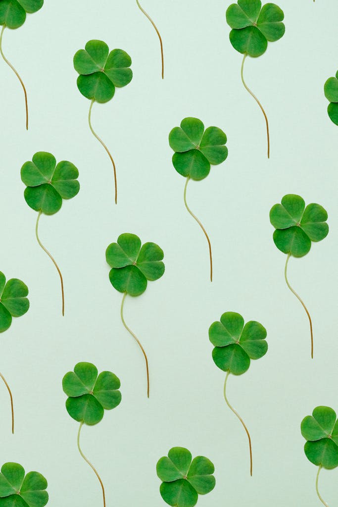 Seamless pattern of green clovers on a light background, perfect for St. Patrick's Day designs.